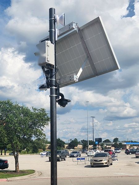 Power unit and solar panel mounted on a parking lot light pole