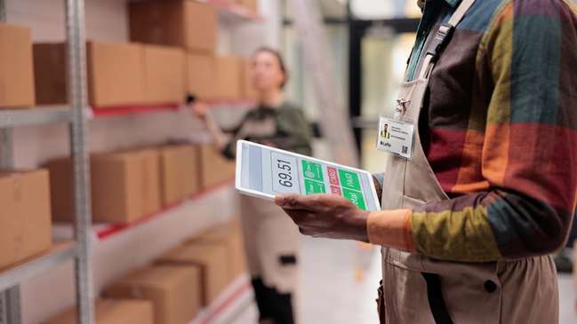 Warehouse associate managing inventory and checkout on a company-issued tablet