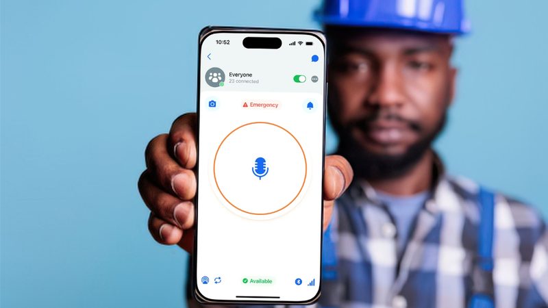 Construction worker holding up a smartphone running a push-to-talk app